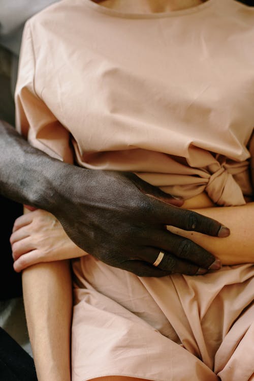 Black Hand and a Person Wearing a Nude Colour Outfit