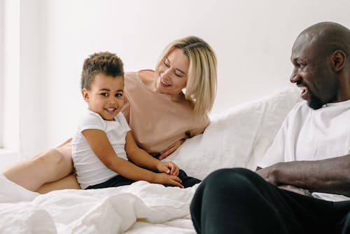 Free A Family Lying Down on the White Bed Stock Photo