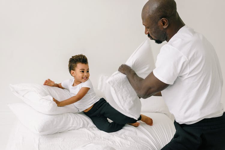 A Father And Son Doing Pillow Fight