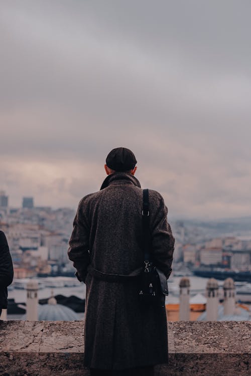 Back View of a Man in a Gray Coat Looking at the City