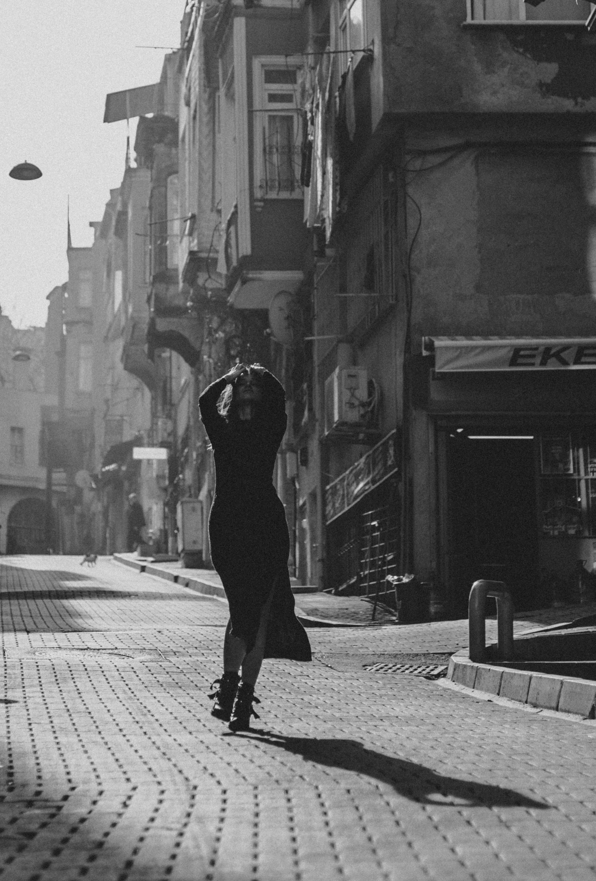 Stylish silhouette of a woman walking down a sunlit street in İstanbul, Turkey.