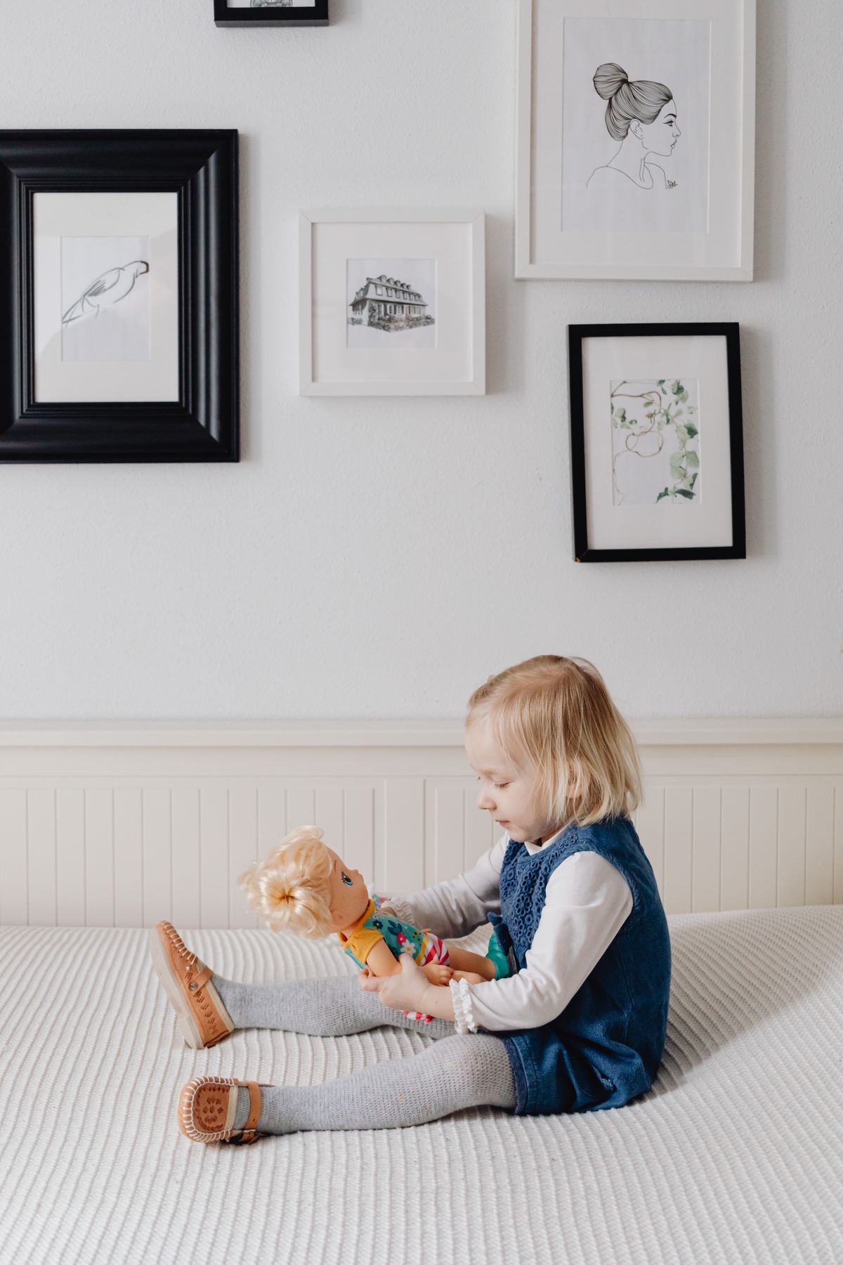 Girl hugging a baby doll in a studio portrait