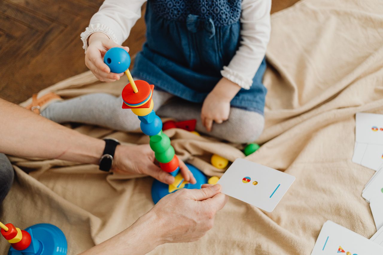 a child playing with colorful educational toys and flashcards indoors