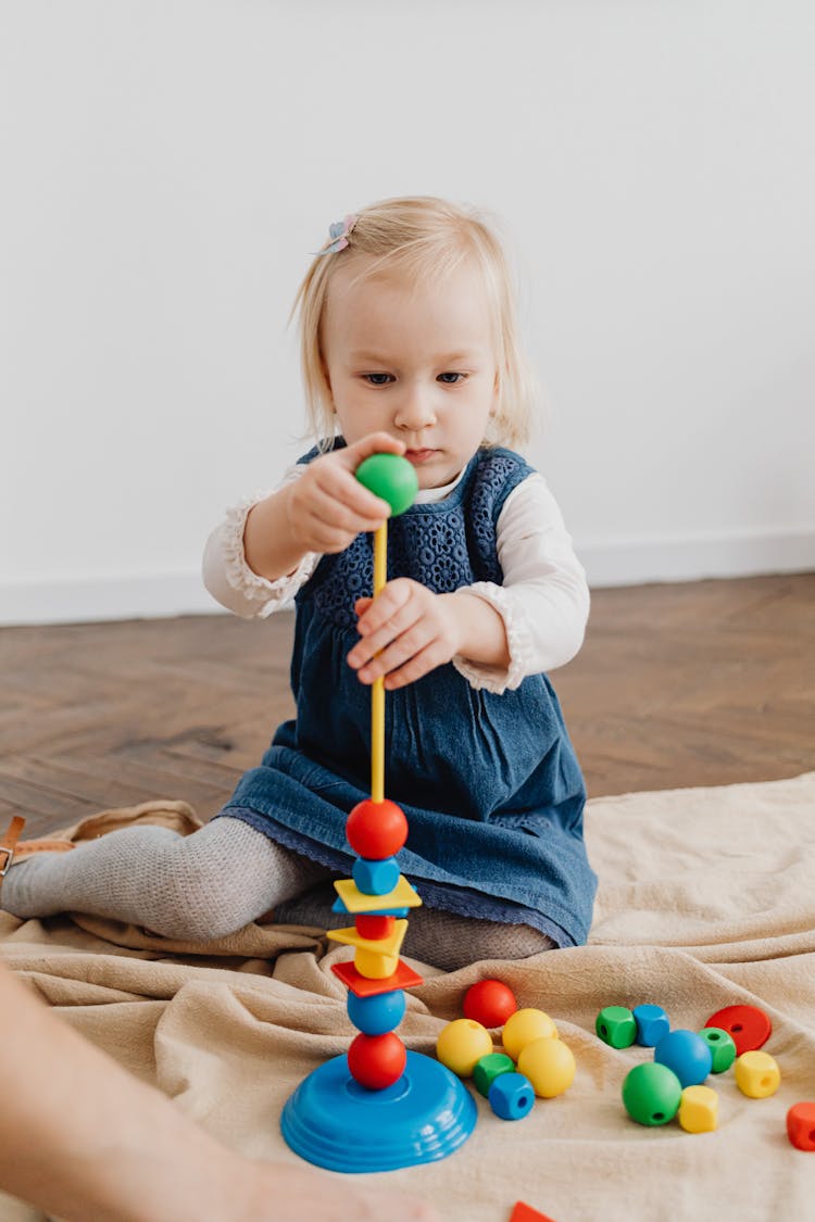 A Girl Playing With Stacking Shapes Toy