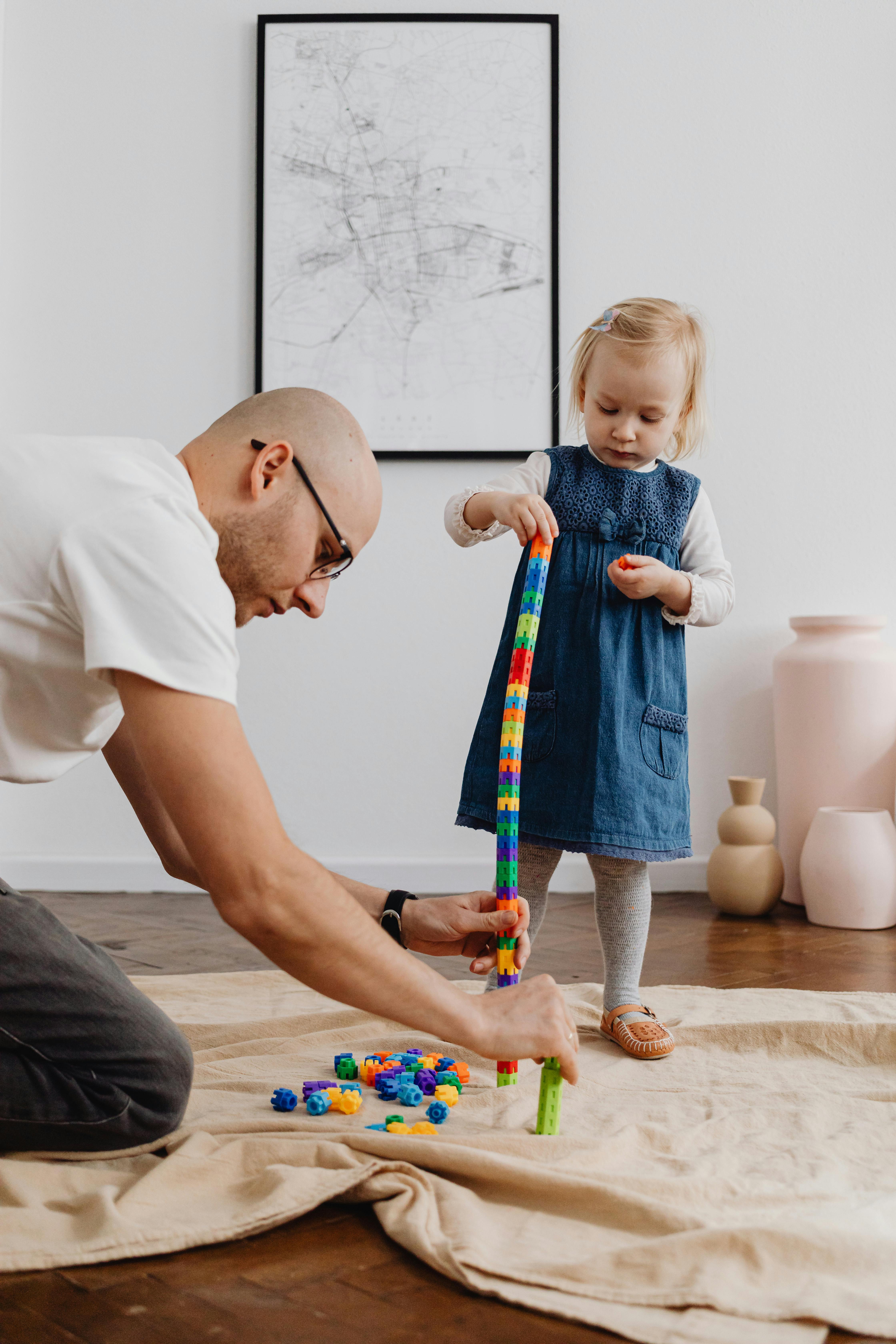 a girl playing with a colorful stacking toy