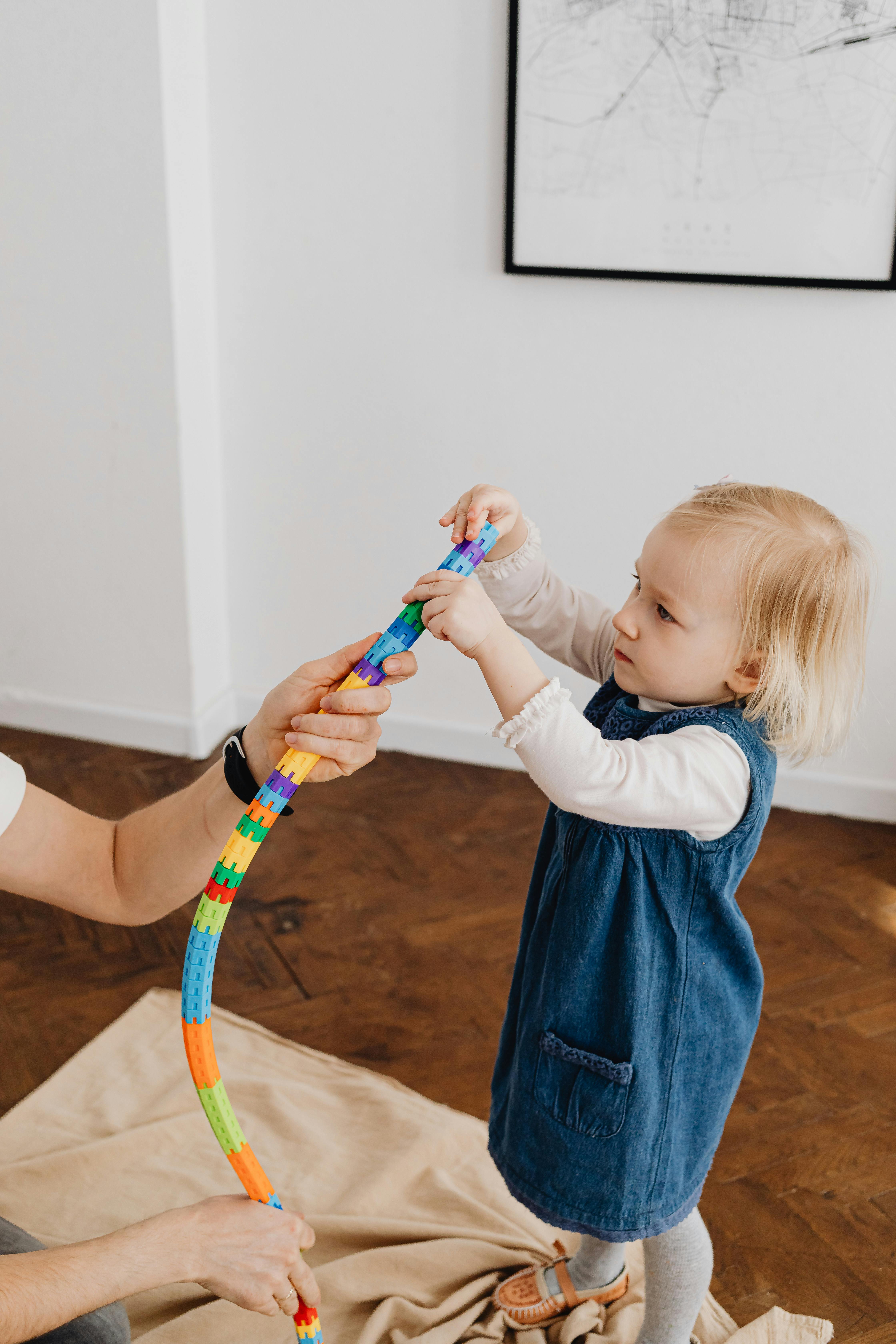 a person helping a child build the tower toy