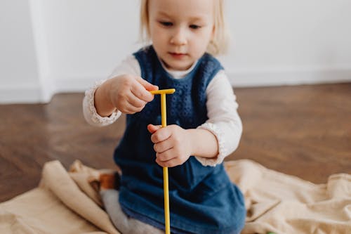 Free Photo of a Girl Playing with her Toy Stock Photo