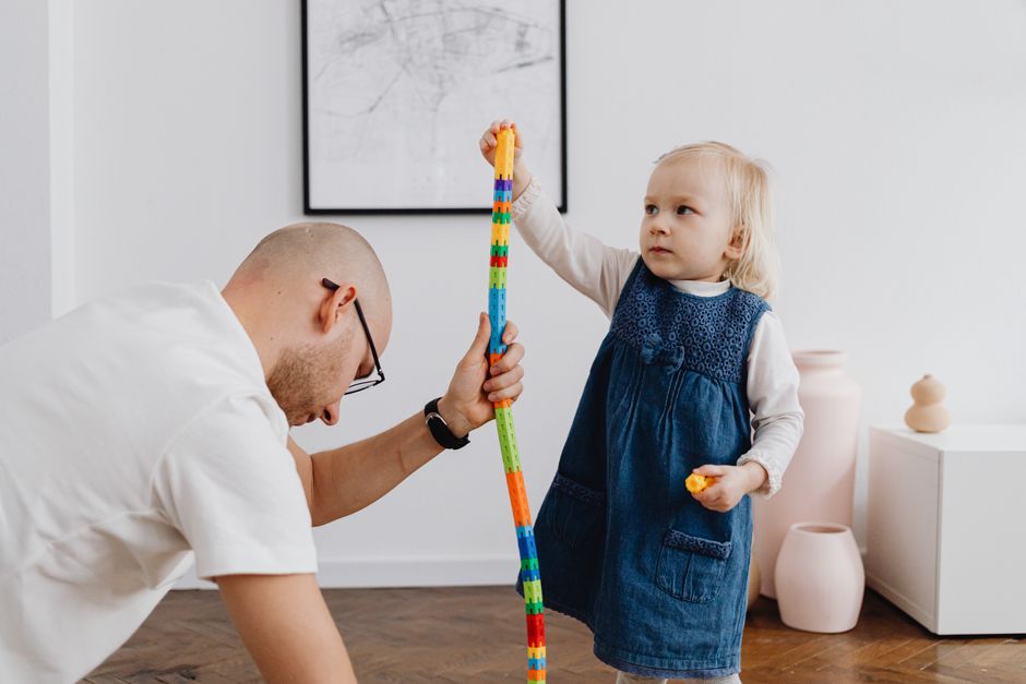 Photo by https://kaboompics.com/ on Pexels Father and daughter bonding through playtime activities, building a colorful block tower. - Photo by https://kaboompics.com/ on Pexels