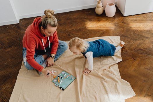 Mother and daughter play together on a cozy indoor setting, sharing quality time and fun.