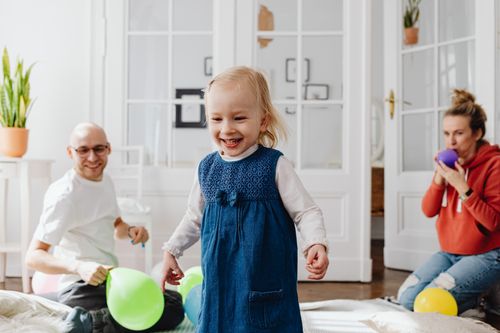 Free Joyful family playing with balloons indoors, showcasing happiness and bonding. Stock Photo