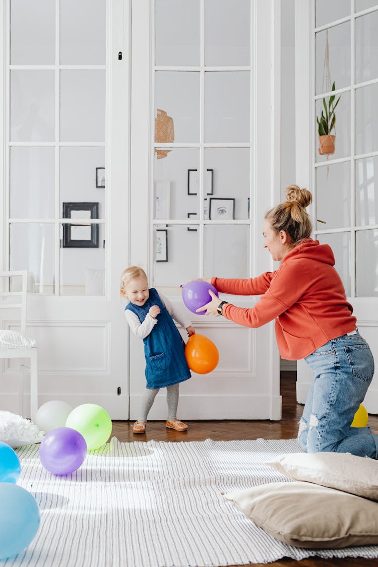 A Mother And Daughter Playing With Balloons