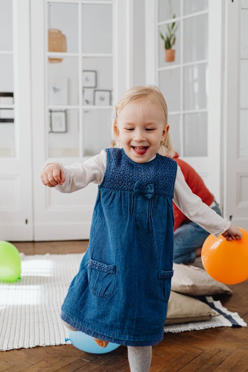 A Girl in Blue Dress Holding a Balloon