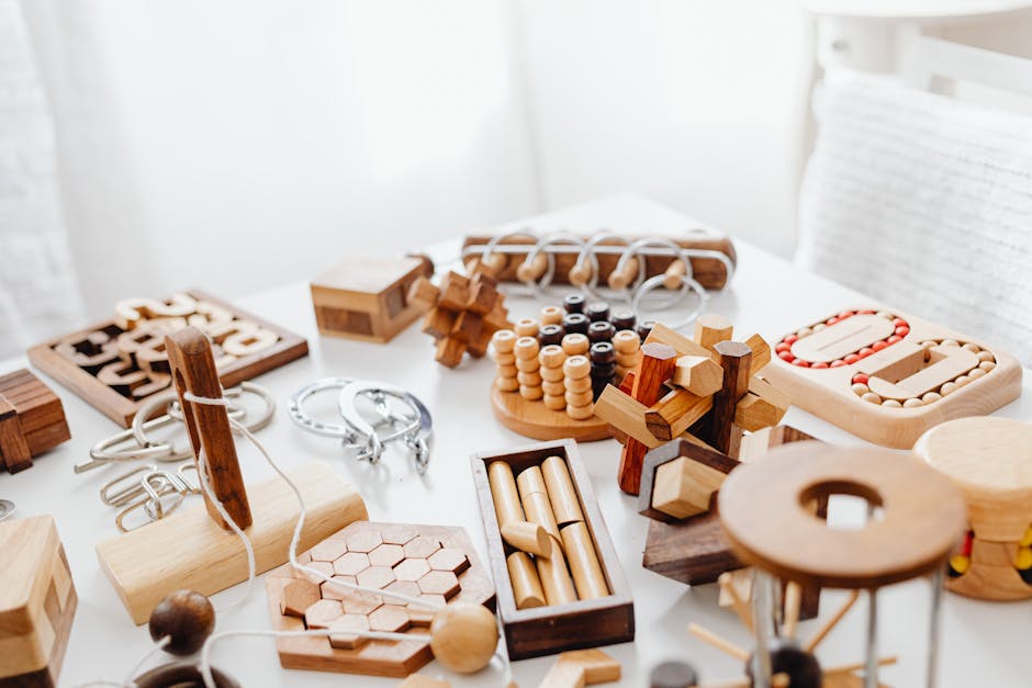 How Puzzle Feeders Ease Separation Stress in Dogs A variety of handcrafted wooden puzzles and games placed on a white table.