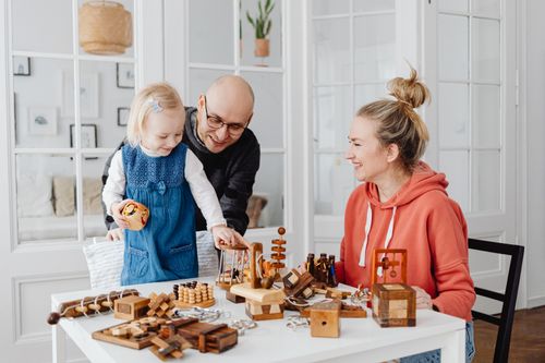 Free A happy family playing with wooden toys indoors, fostering creativity and bonding. Stock Photo