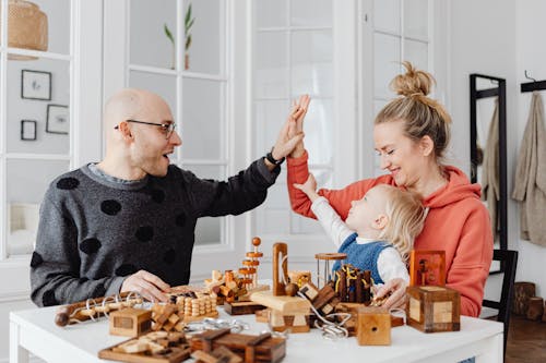 Happy Family with Child Playing Wooden Games Together