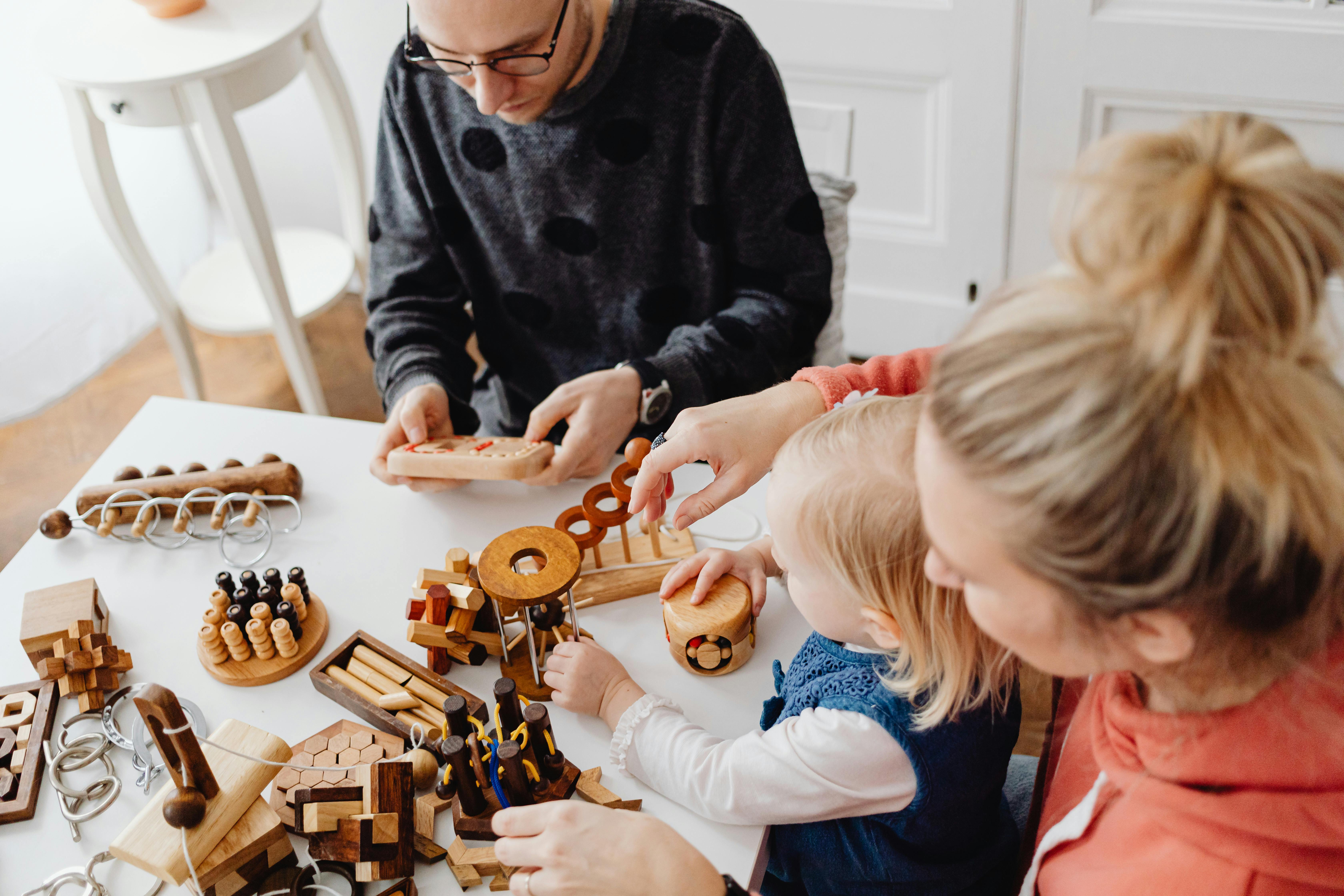 A family playing with wooden educational toys, enjoying quality time indoors.