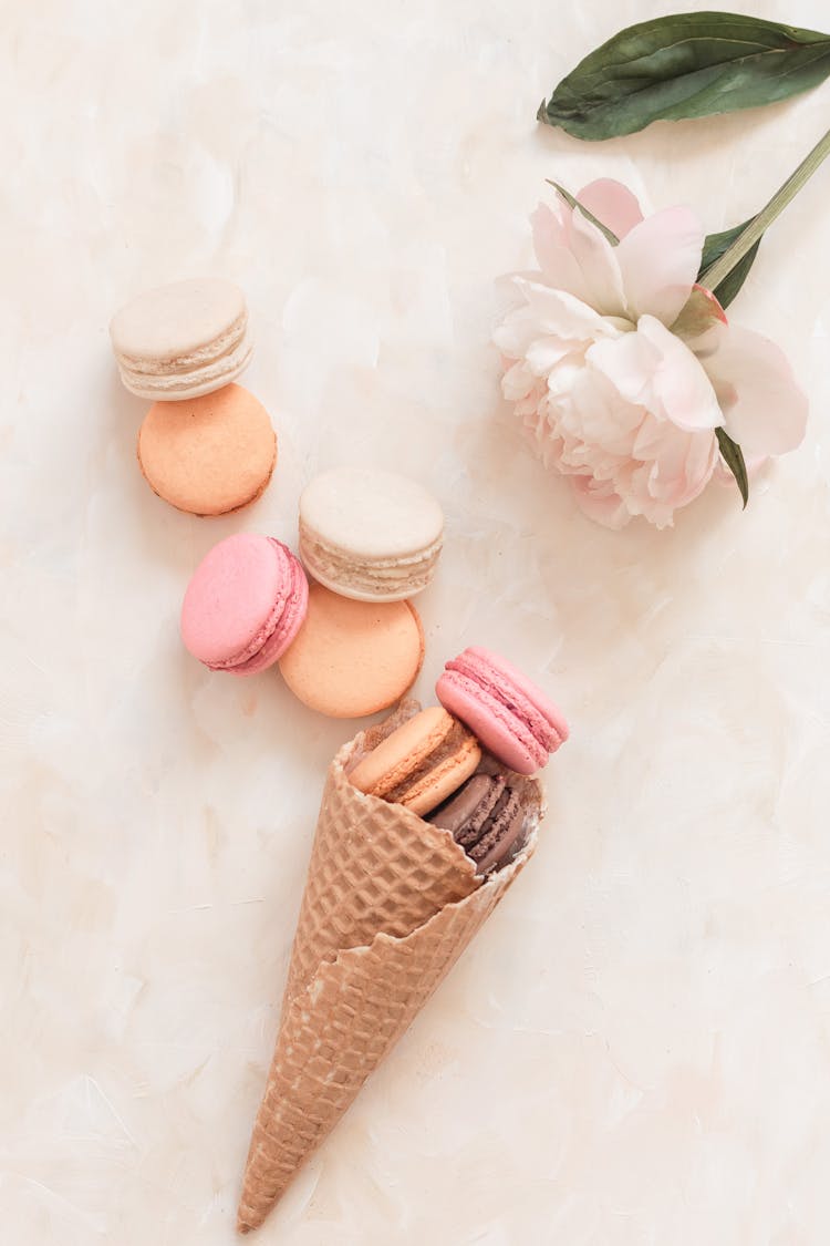 Waffle Cone With Macaroons On Table Near White Flower