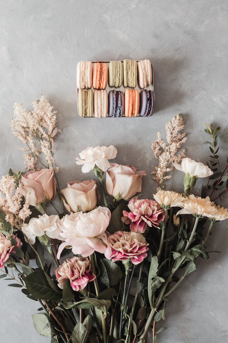 Bouquet On Table Near Sweet Macaroons In Box