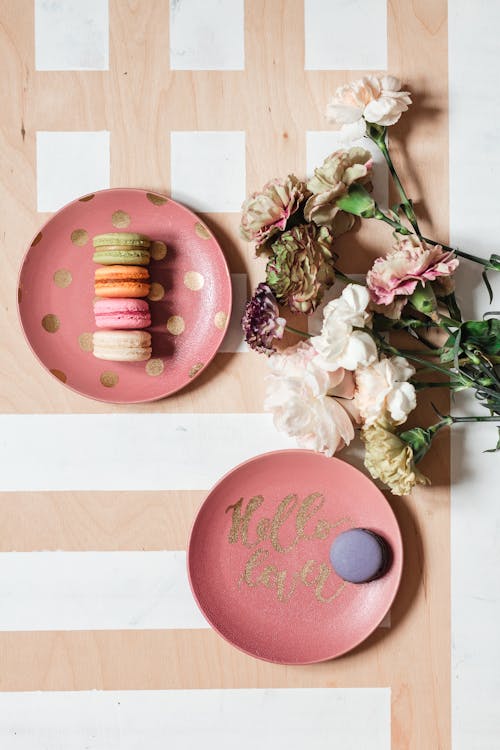 Blooming Flowers and Plates With Macaroon Cookies