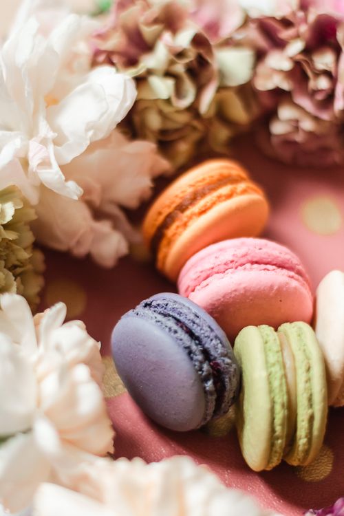 Free Vibrant macarons arranged with delicate flowers, creating an artistic and colorful composition. Stock Photo