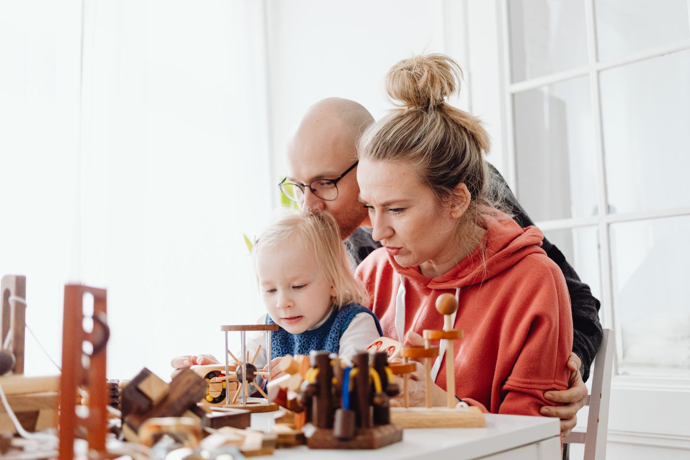 Parents and child playing together with toys