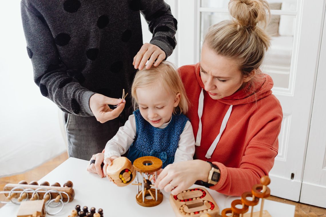 Family sharing thoughtful play with wooden educational toys