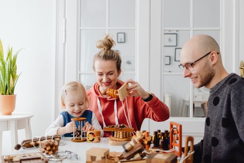 Free Family enjoying quality time playing with wooden toys in a cozy home setting, fostering creativity and bonding Stock Photo