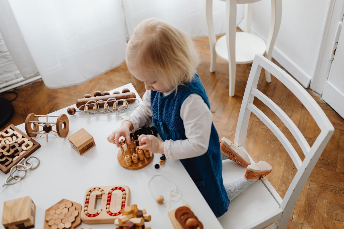 Child exploring wooden educational materials at a table