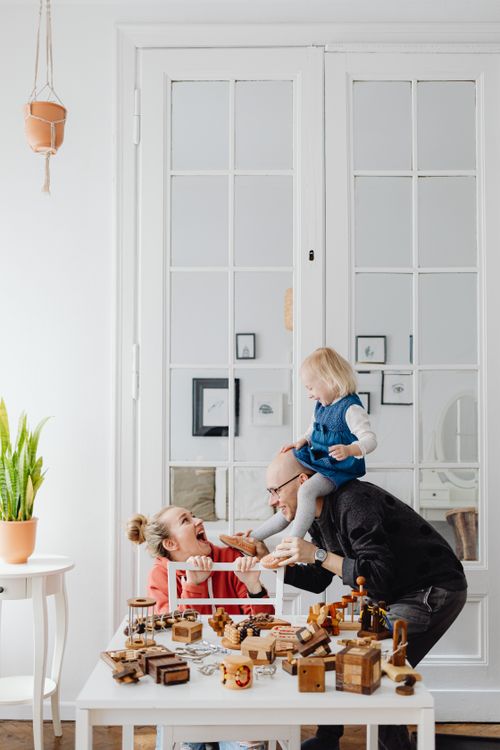 Free A joyful family bonds indoors playing with wooden toys, capturing a moment of togetherness. Stock Photo