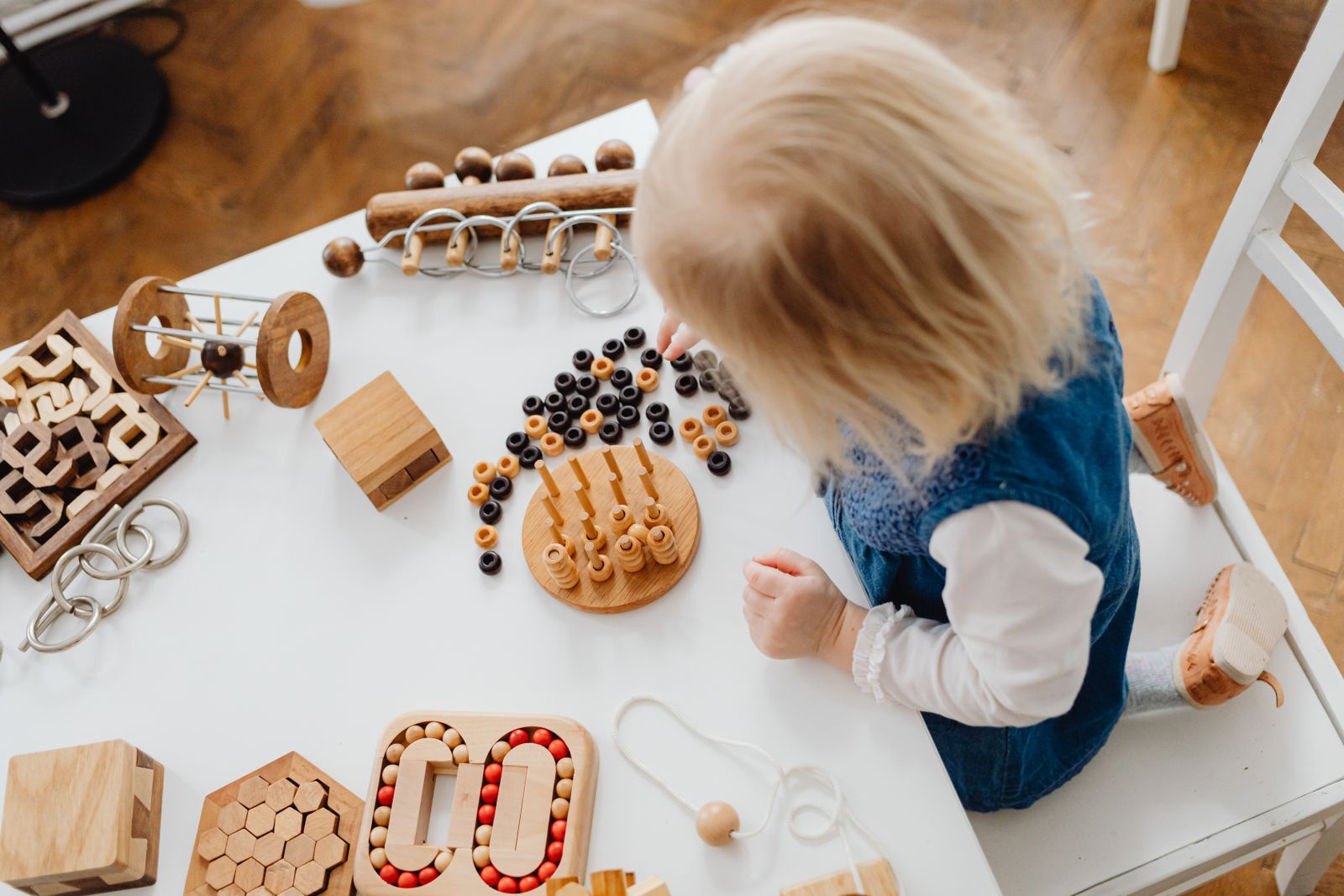 A young child using wooden educational toys at a table during a creative problem-solving activity