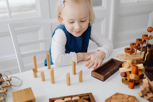 Free A Young Girl Looking a Wooden Toys Stock Photo