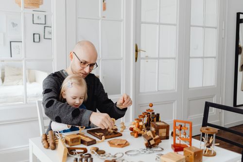 Free Father and daughter enjoying quality time playing with educational wooden toys indoors. Stock Photo