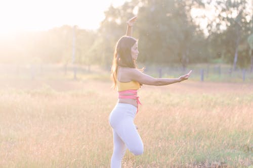 A Woman Standing on the Field while Doing Yoga