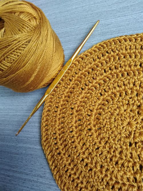 Free Close-up of golden yarn and crochet hook on a textured surface. Stock Photo