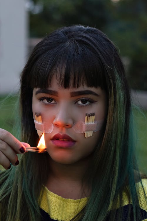 Portrait of a Woman Holding Lit Matchsticks Near Her Face