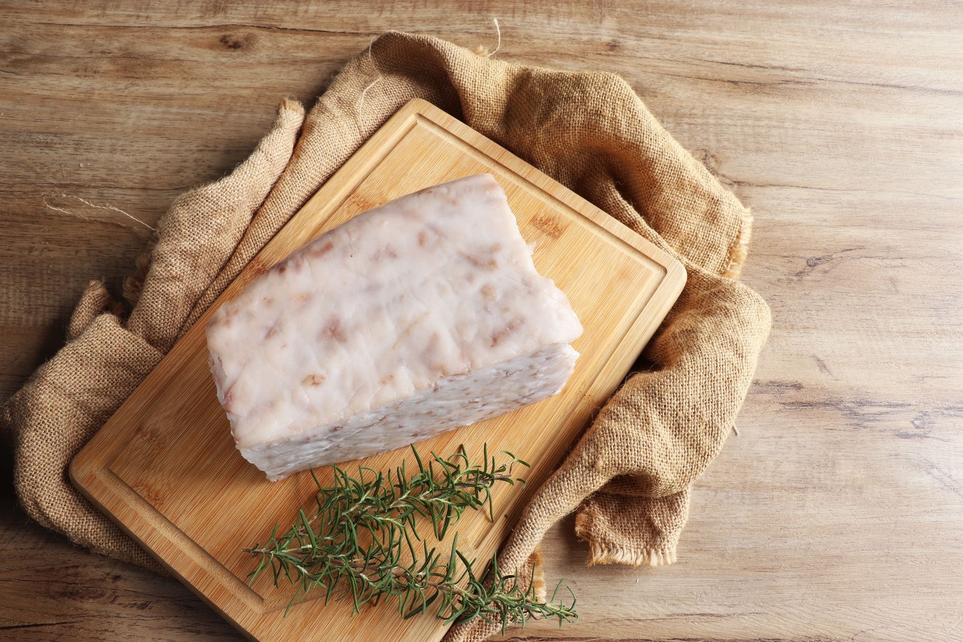 Rendered beef tallow in a glass container with a spoon