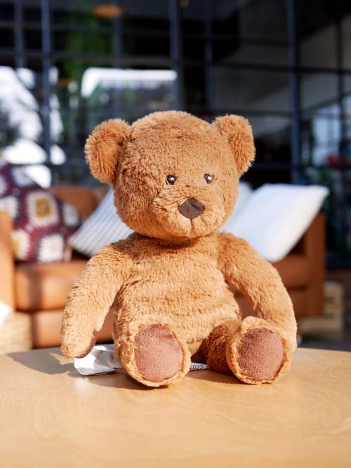 Close-Up Photo of a Brown Teddy Bear on a Wooden Table