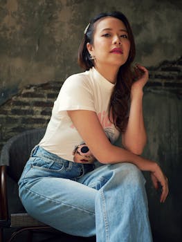 Confident woman posing indoors in casual blue jeans and stylish top.