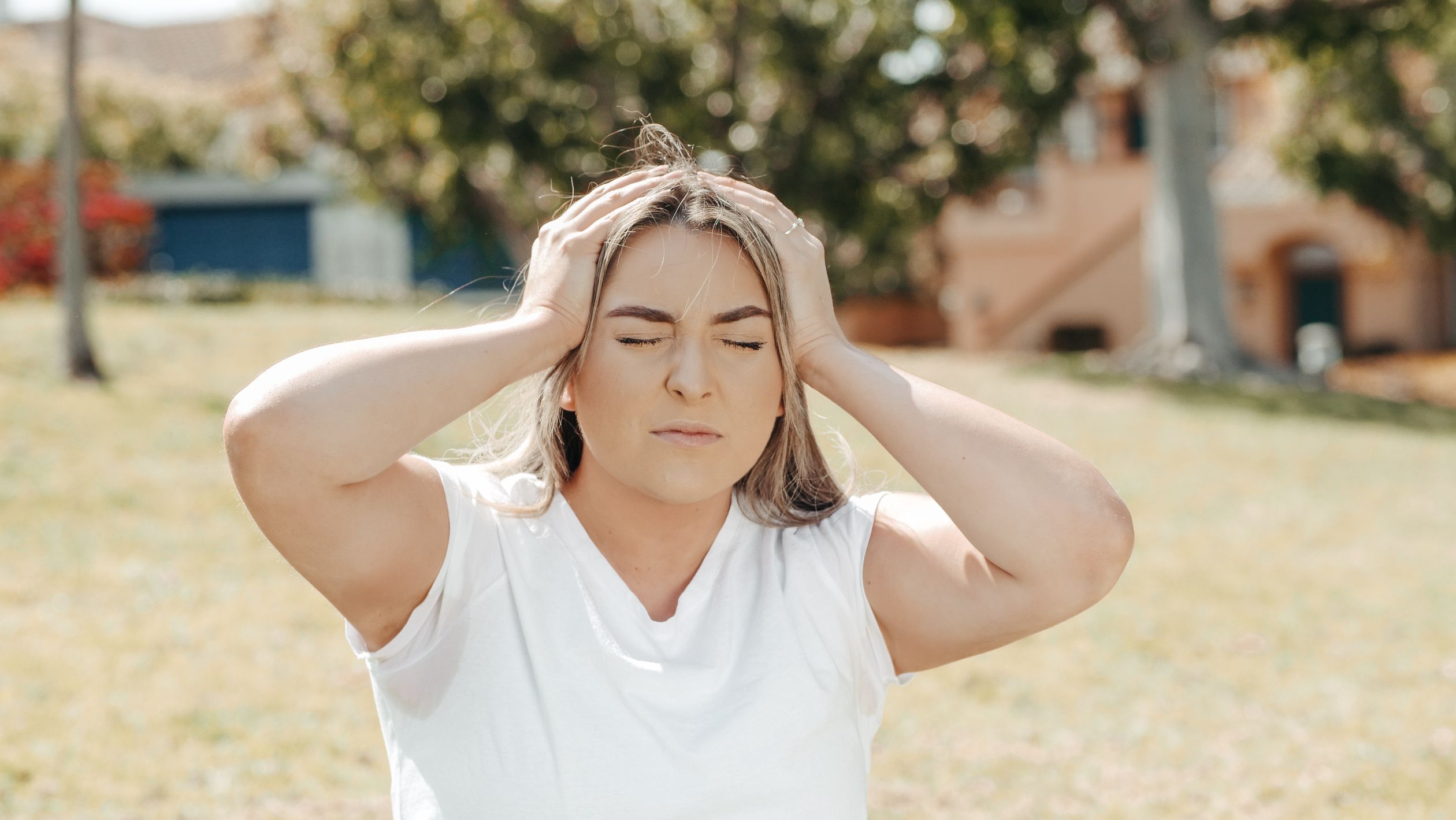 A Woman Holding her Head While Eyes Closed · Free Stock Photo