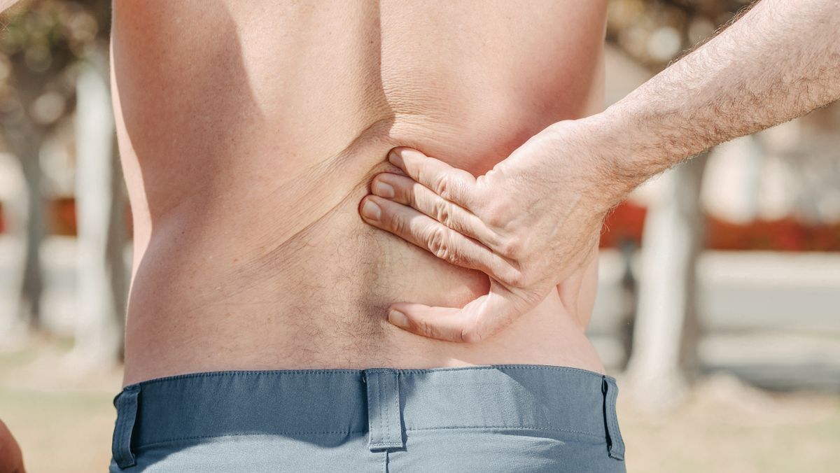Man experiencing lower back discomfort from poor posture