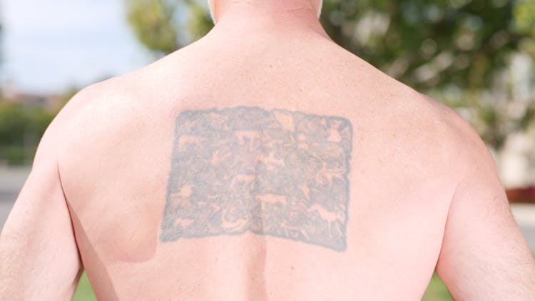 A Man With Tattoo On His Back