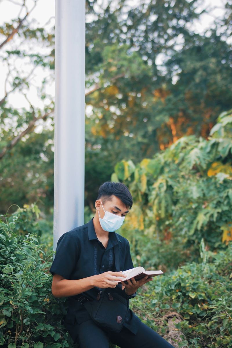 Person reading a printed book outdoors