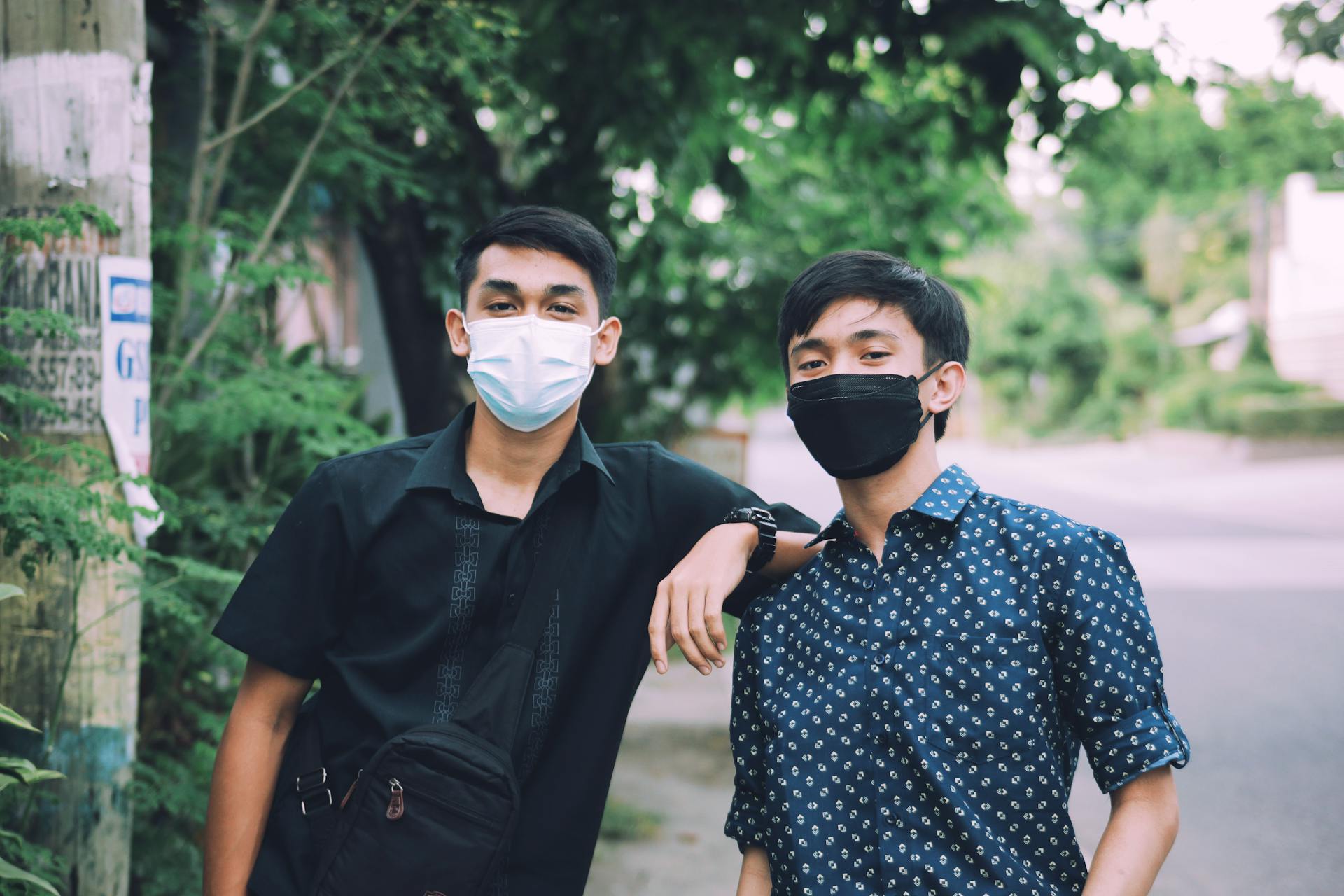 Two young men wearing face masks standing outdoors symbolizing health and safety during the pandemic.