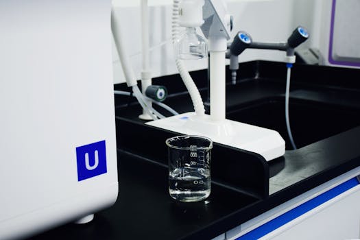 Close-up of modern laboratory equipment including a glass beaker and apparatus in a professional lab setting.
