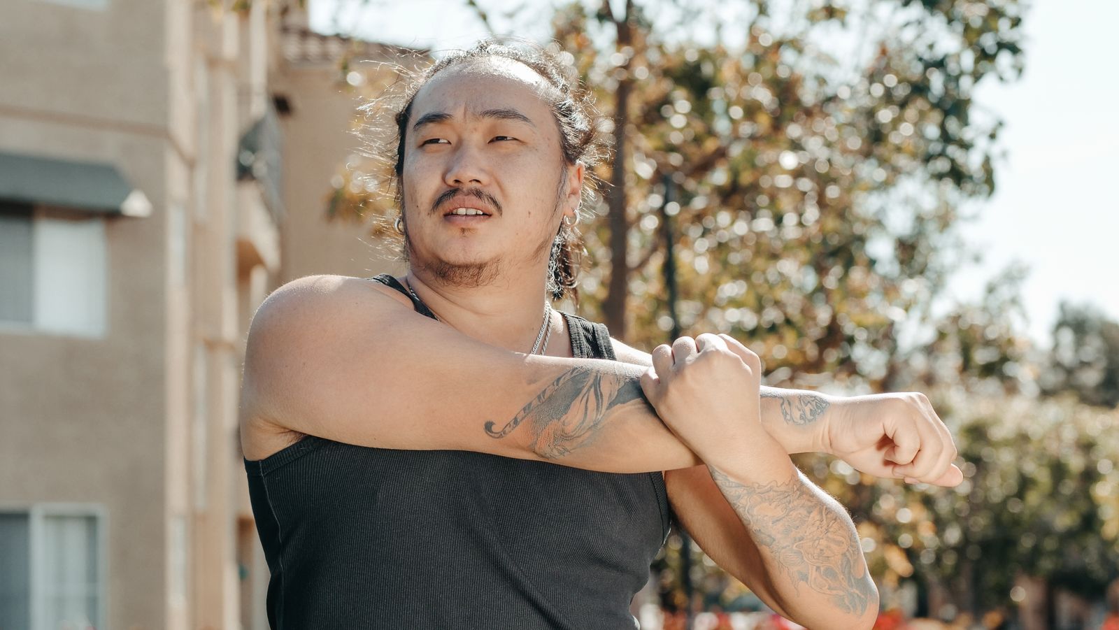 Person outdoors stretching an arm and elbow in bright daylight