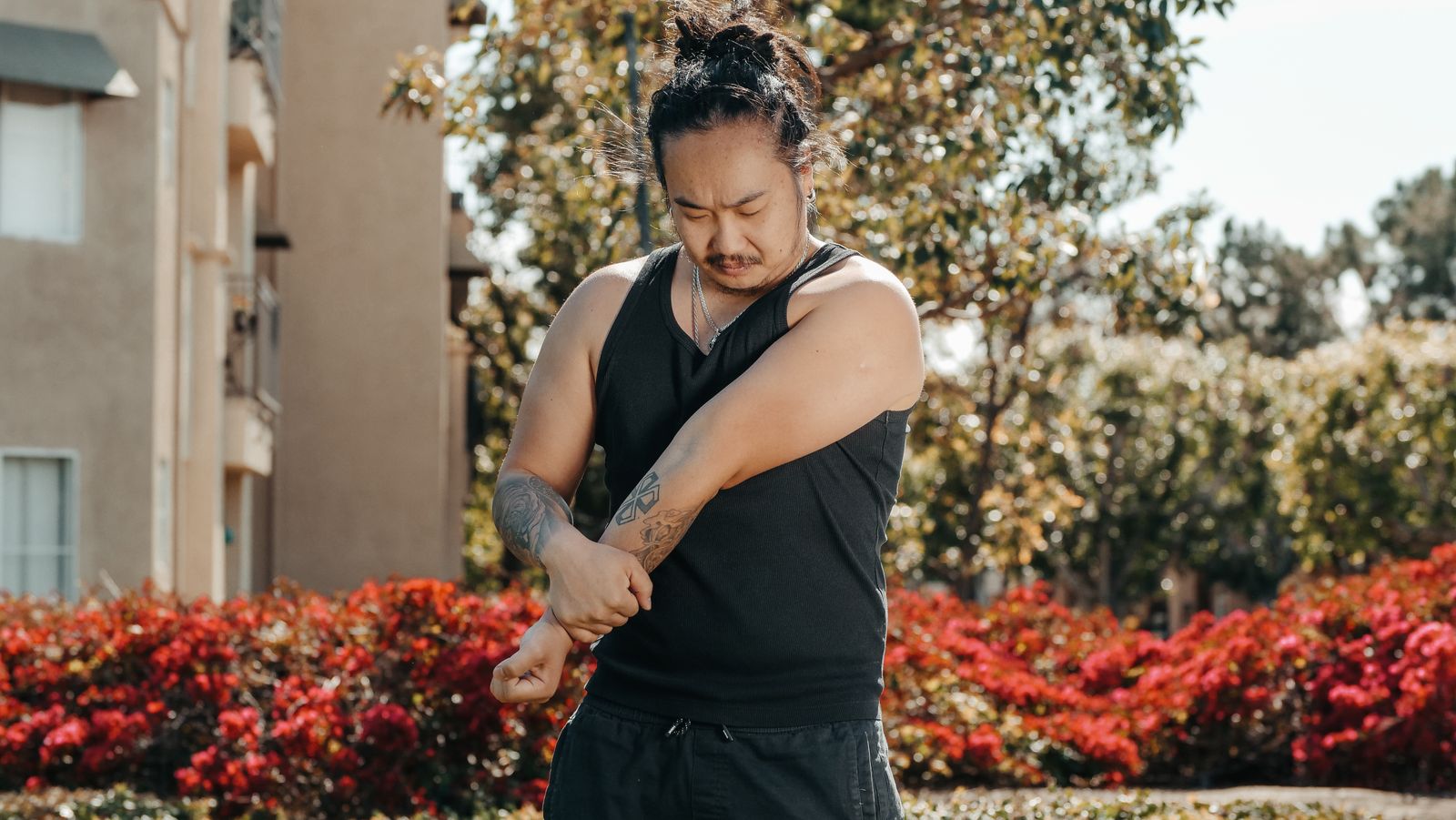 Person outdoors holding their elbow during an active warmup