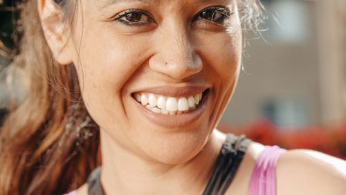Free Close-up of a smiling woman enjoying a sunny day outdoors. Stock Photo