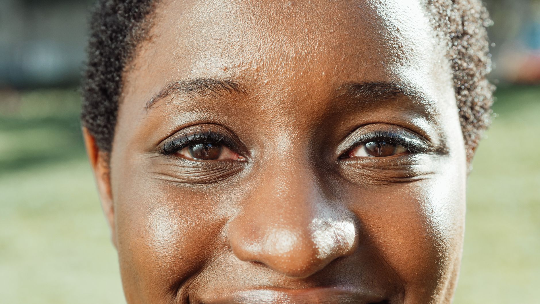 A close-up of a face lit up with genuine, relaxed warmth — the open signal that makes a moment possible.