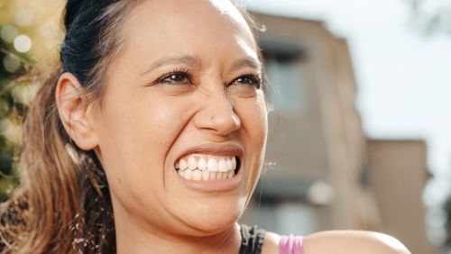 Free Vibrant close-up of a woman smiling outdoors on a sunny day. Stock Photo