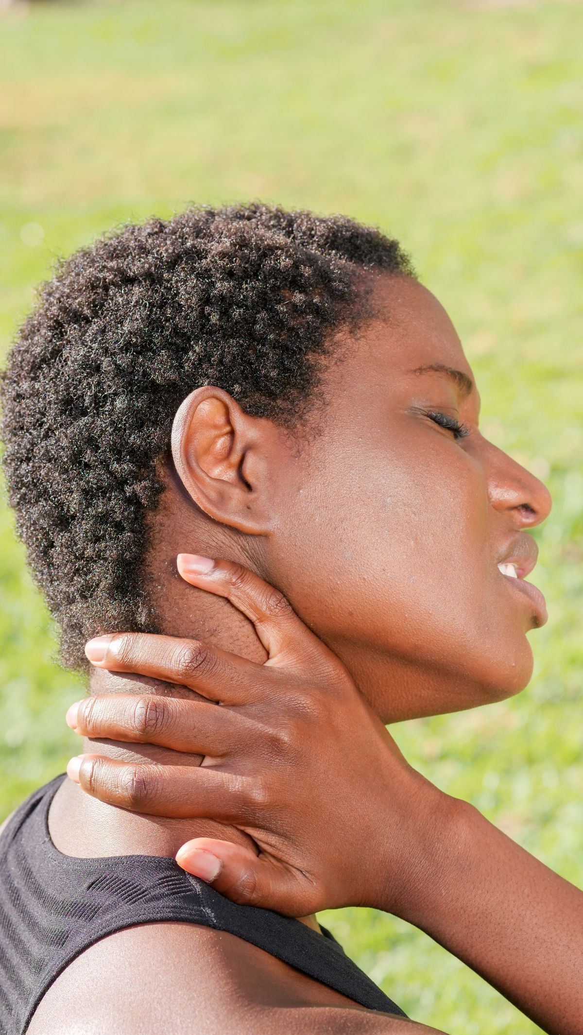 Close-up of a person holding their neck, easing tension